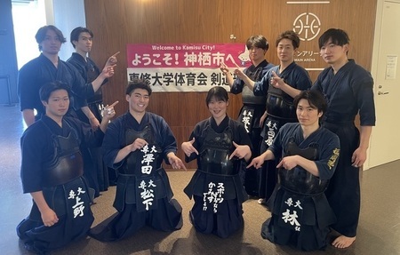 写真:専修大学体育会剣道部を歓迎する看板前でポーズを取る部員達