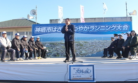 写真：2025年2月23日波崎体育館前にて撮影。ステージ上でマラソン参加者に挨拶をする市長