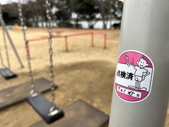 写真：点検が完了し、安全が確認された遊具と点検済シール