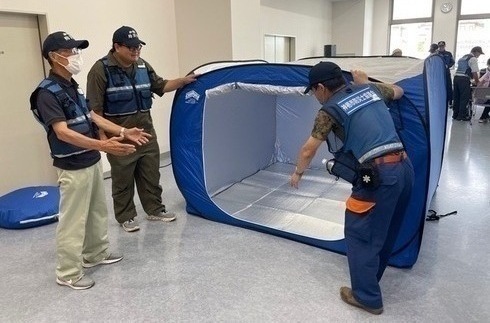 写真:3人で協力してパーテーションテントを設営する防災士
