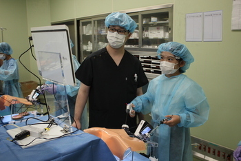 写真:医師の指導の下、実際の手術道具を使った手術体験をしているようす