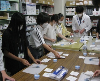 写真:医師の指導による調剤体験を黙々と作業をする参加者