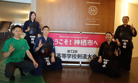 写真:ウェルカム看板の前で記念撮影。茨城県代表として出場する神栖市出身の選手たち