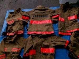 写真：ブルーシートの上に並べられた子ども用の防火服