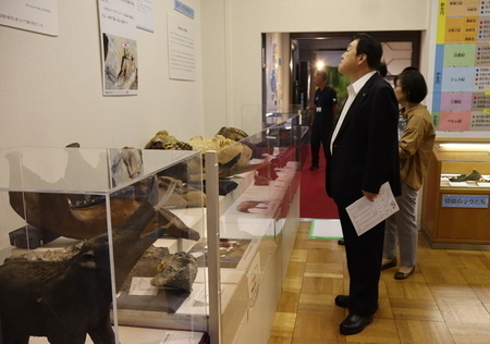 写真：2025年7月22日歴史民俗資料館にて撮影。展示ケースの前の石田市長。