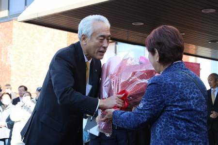 写真：2025年12月8日撮影。支援者から花束を受け取る市長