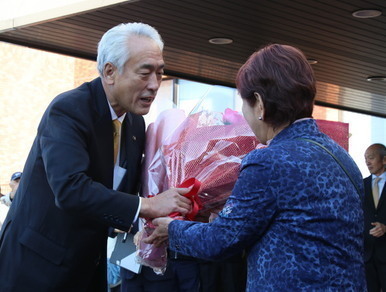 写真：2025年12月8日撮影。集まった皆さんが見守る中、花束を受け取る市長