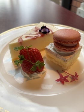 画像：白い皿にケーキやマカロンなどが盛り付けられたデザートプレート