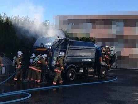 写真：充電池などがパッカー車の中で発火し、消火作業に当たる消防士達