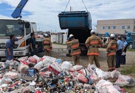 写真：消防署職員および警察官立ち会いのもと、パッカー車の内部を確認するようす