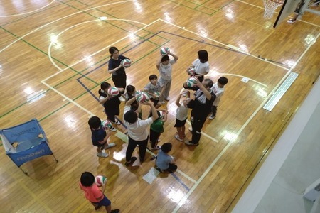 写真：オーバーハンドパスを教えてもらう参加者たち