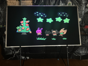 写真：ブラックパネルシアターに果物が実るツリーや動物などの絵が浮かび上がっている