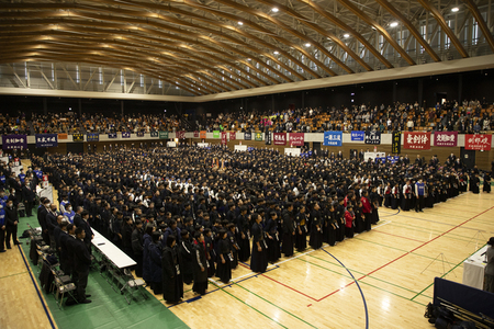 写真：体育館内でおこなわれた開会式。参加した剣士が整列しているようす。