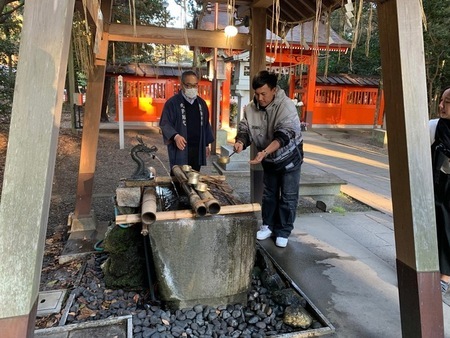 写真:息栖神社の参拝で、柄杓で水をすくう参加者の様子