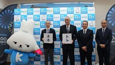 写真：2026年3月23日撮影。「トト」「ネネ」という名前が書かれた額を手に持って記念撮影