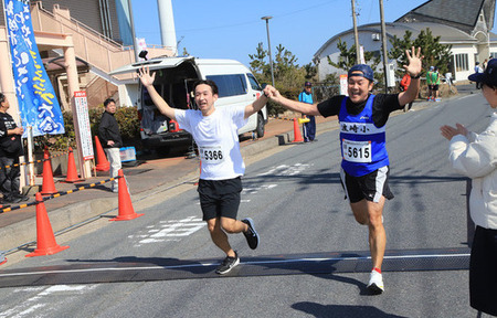 写真：ともに手を上げ笑顔でゴールを喜び合う参加者達