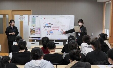 写真:実習生に緊急時の連絡する番号を教える様子