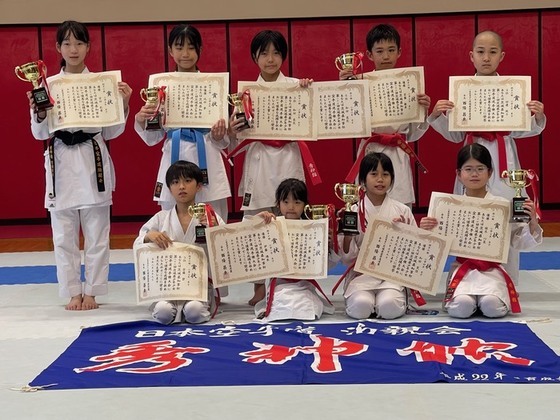 写真:大会で入賞し、賞状やトロフィーを手に持ち記念撮影をする子どもたち