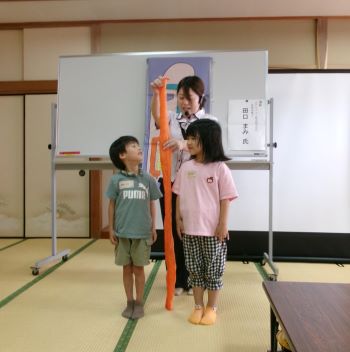 写真:腸管模型を使用して子ども達の身長と腸の長さを比べている様子