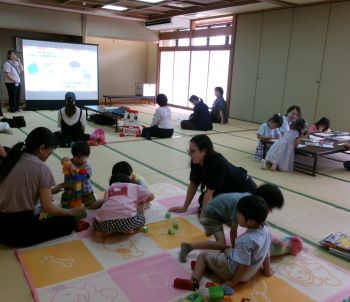 写真:保護者への講座中に後方で子ども達が遊んでいる様子