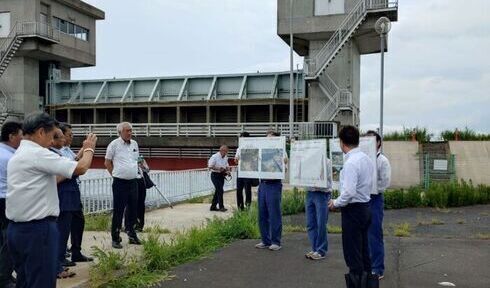 写真:逆水門にて、職員からナガエツルノゲイトウの繁茂状況の説明を受ける木内市長と市長会の皆さん